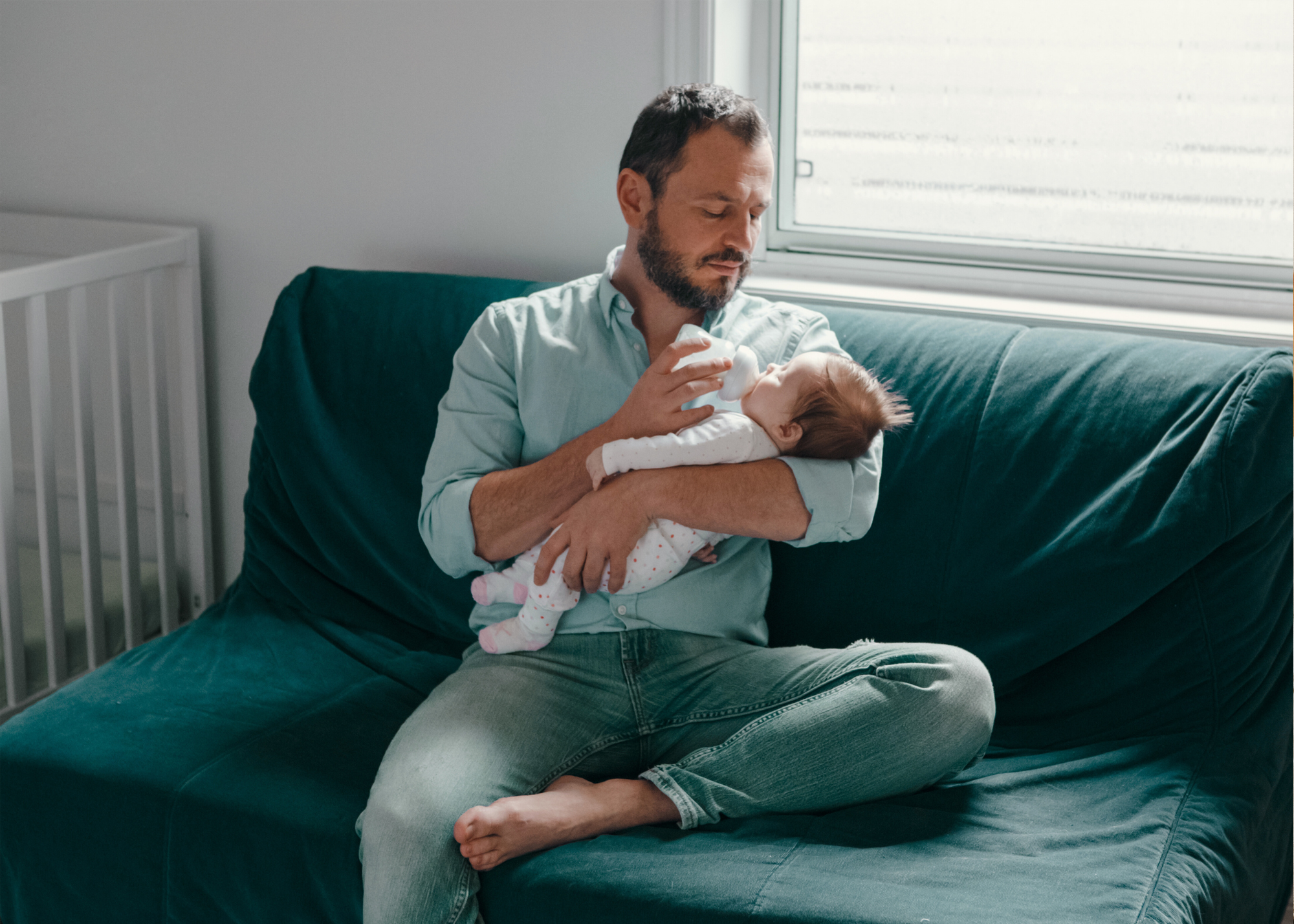 Father holding baby in front of window